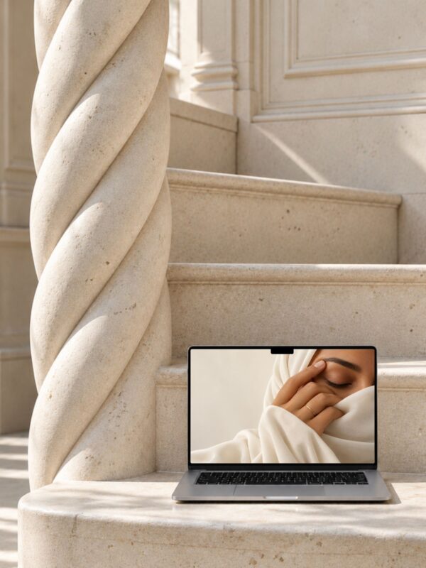 Mockup MacBook Canva sur un escalier en pierre au pied d'une colonne torsadée